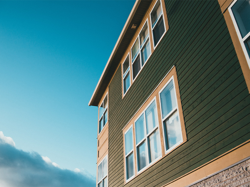 green siding on a two-story residential home