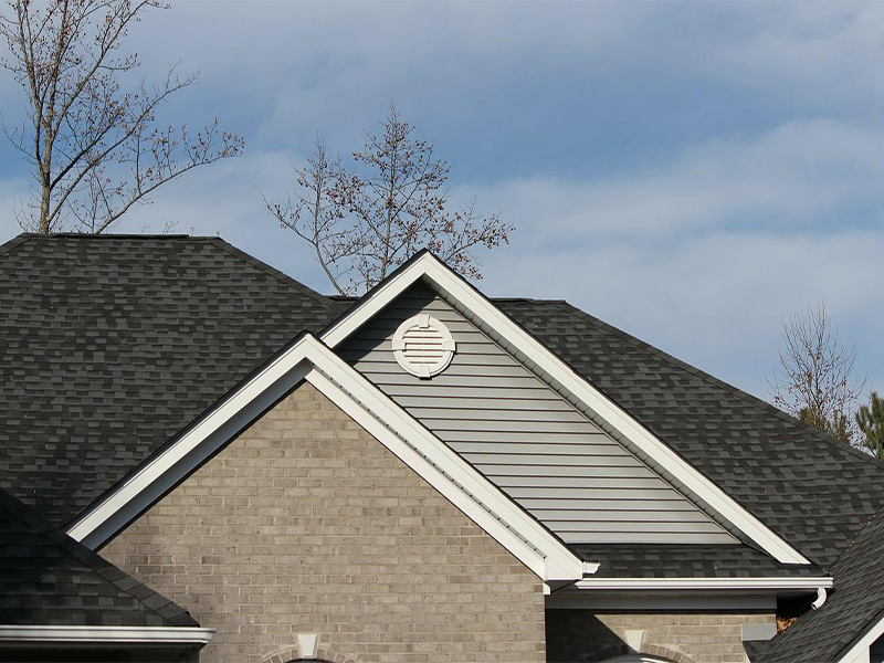 brick home with black asphalt shingles