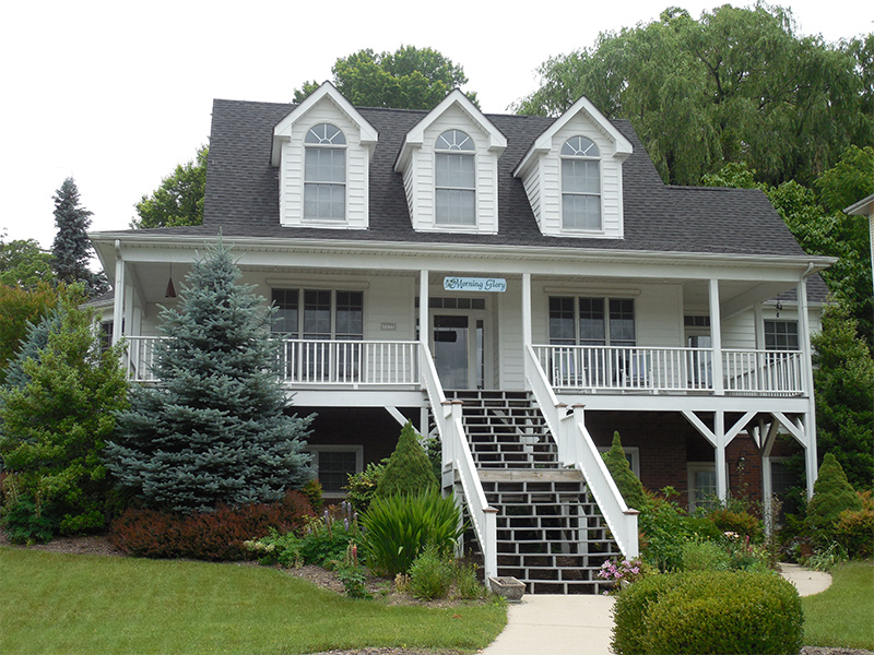 white cottage with a black asphalt roofing