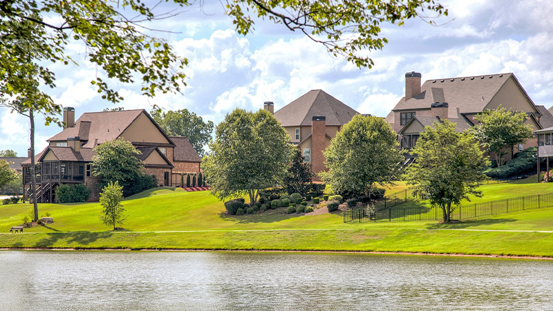 modern brick homes sitting along a lake